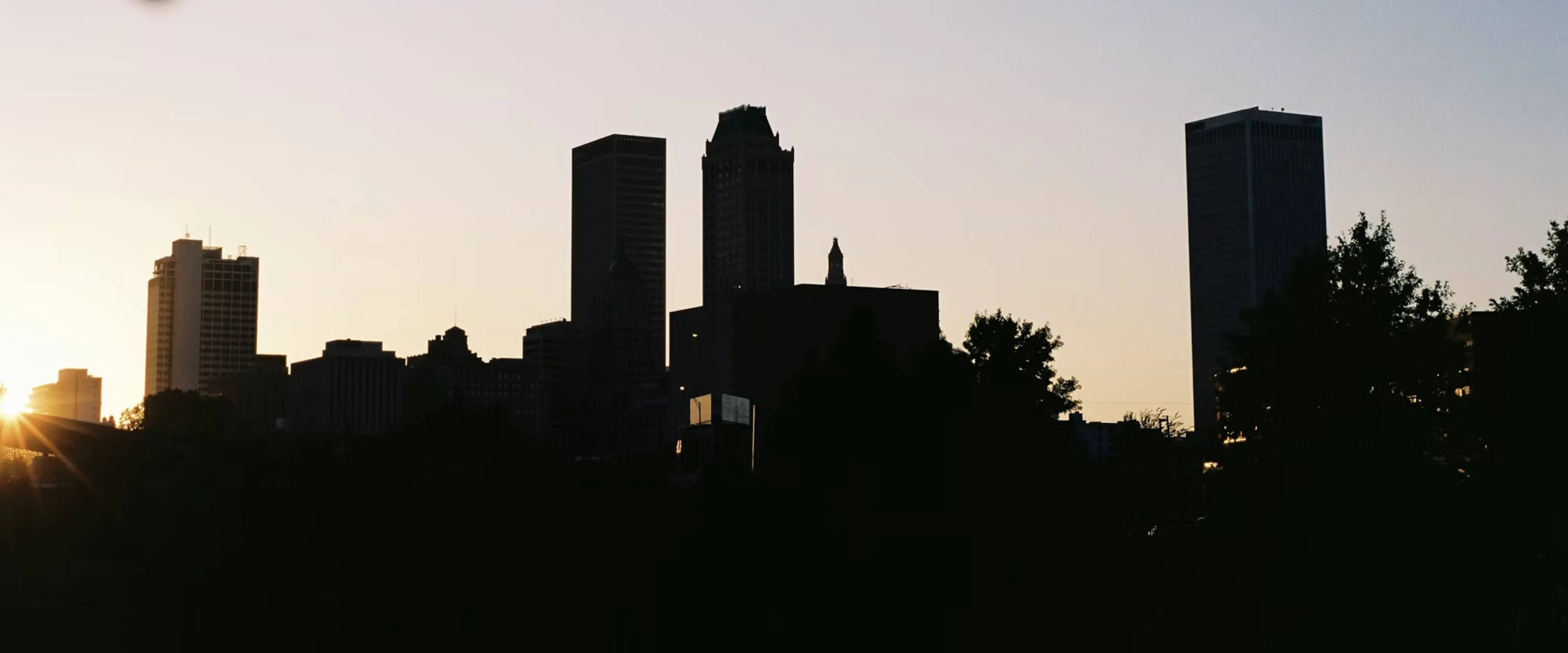 Silhouette of Tulsa skyline at sunset.