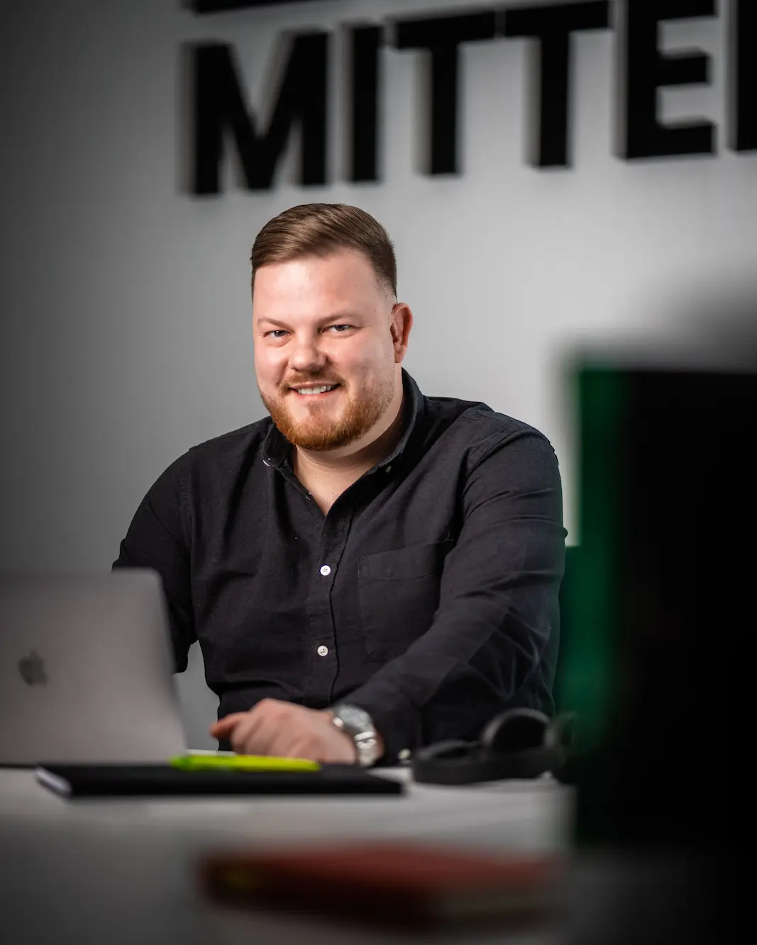 Berater mit Kopfhörern vor dem Bildschirm