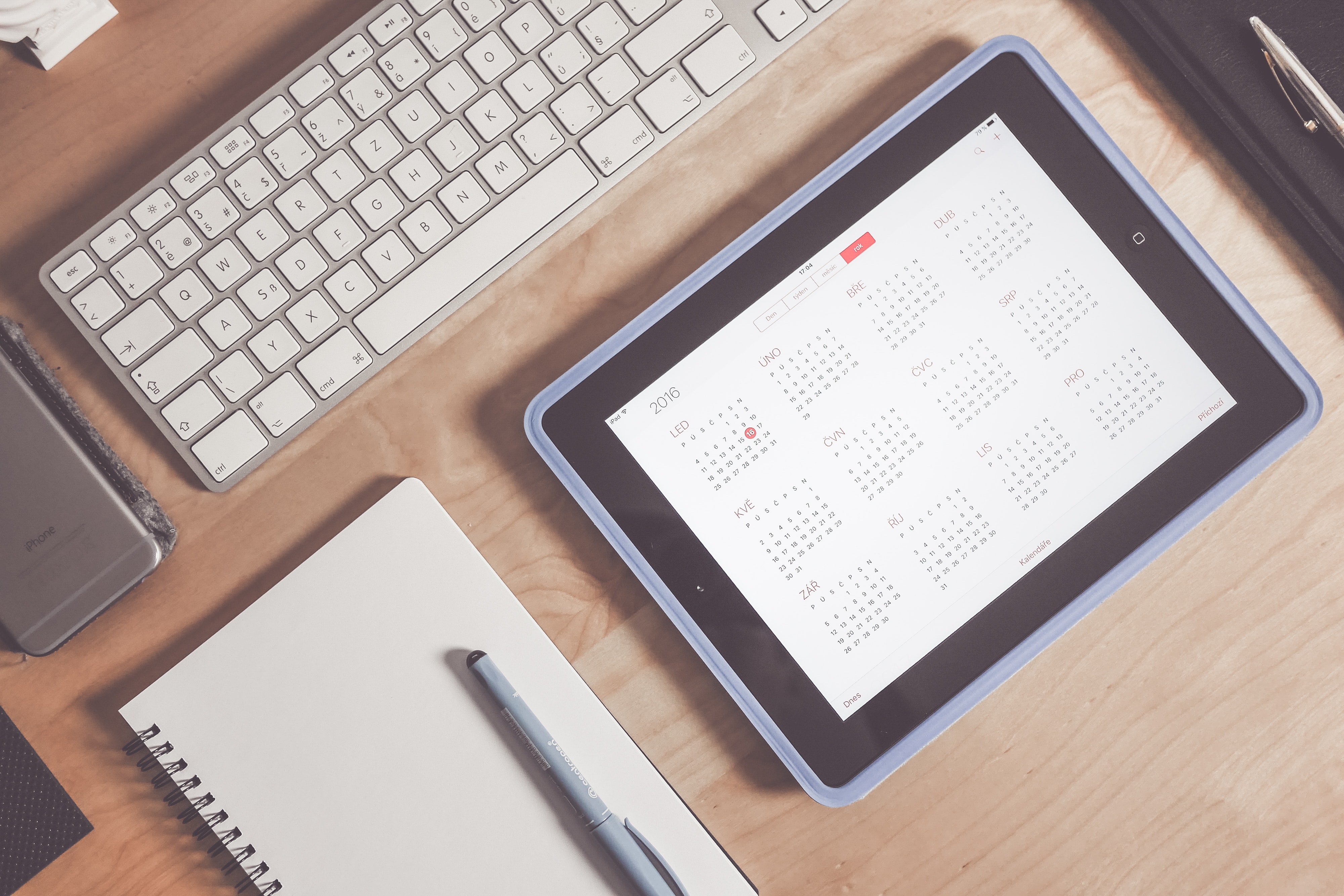 Calendar on a tablet screen with a keyboard and notebook