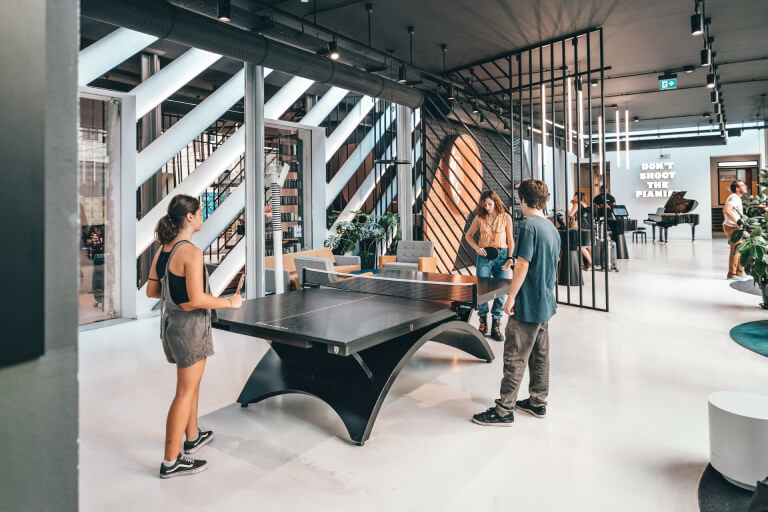Coworkers playing table tennis