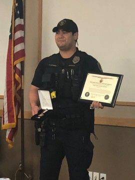 Officer Suyama holding awarded medal