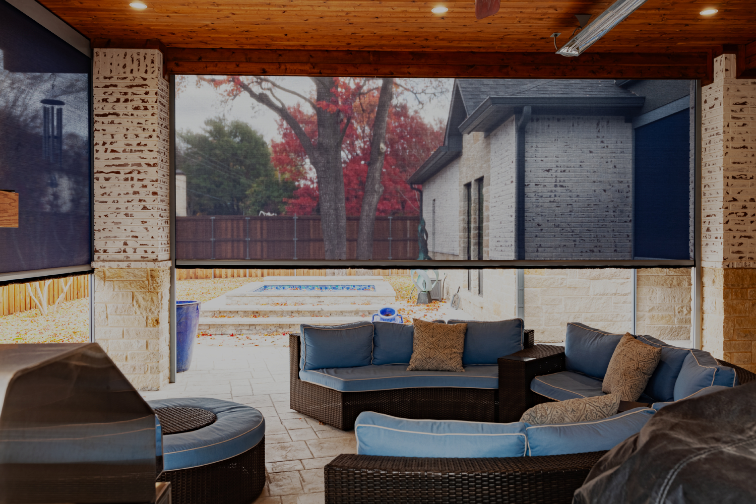 Patio with outdoor shades, wicker furniture.