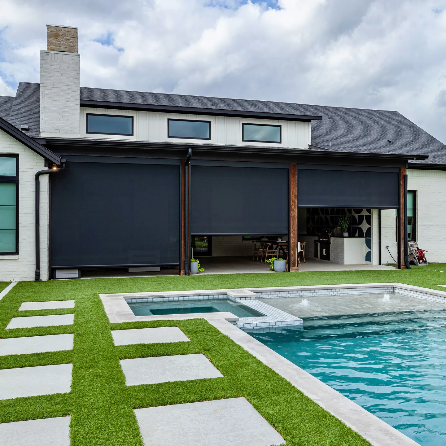 Home exterior with retractable solar screens over pool and patio