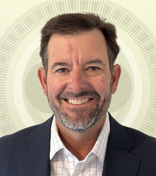 Headshot of Jeff Hawkins wearing a suit against a tan background
