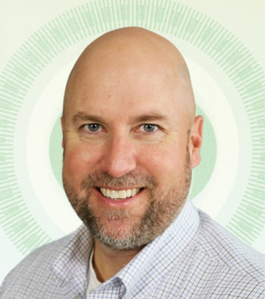 Headshot of Managing Director John Scambray against tan background