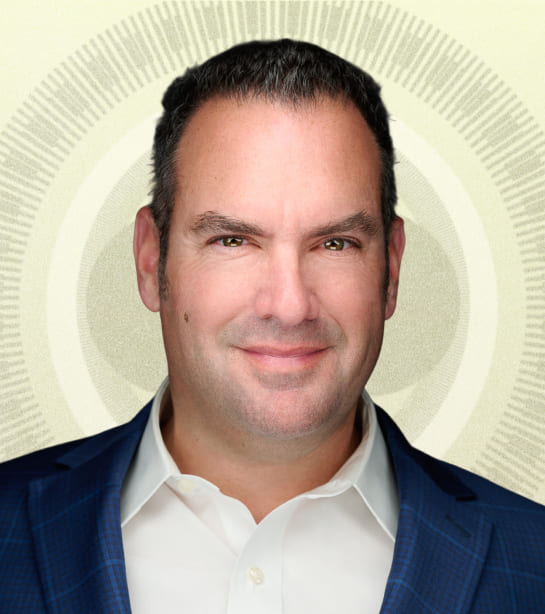 Headshot of Keith Woomer against tan ripple background