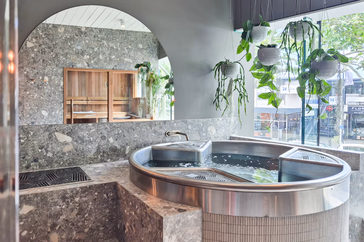 room covered in stone titles with a shower and sauna
