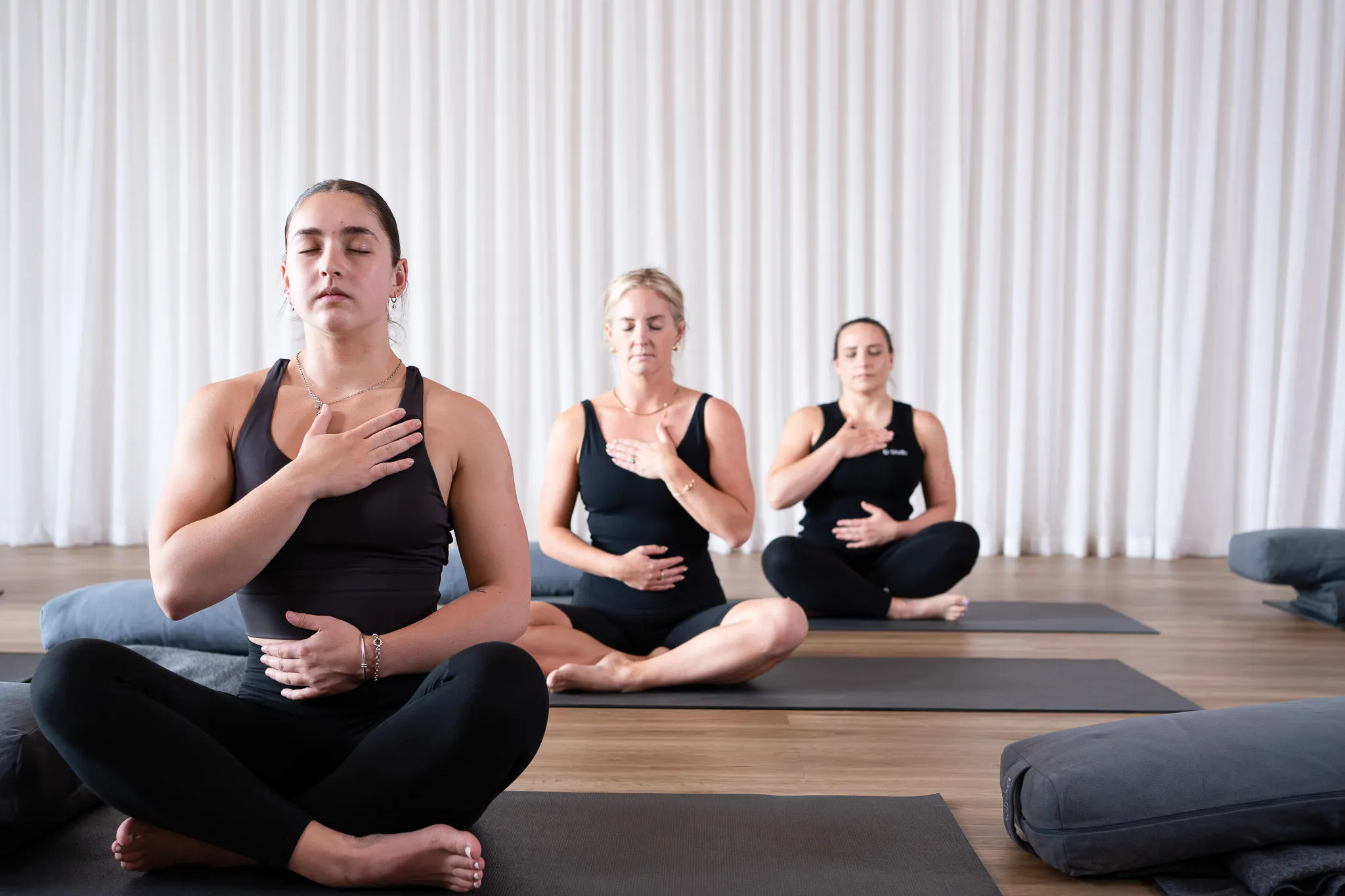 Group breathwork session at O‑Studio with women practising mindful breathing on yoga mats