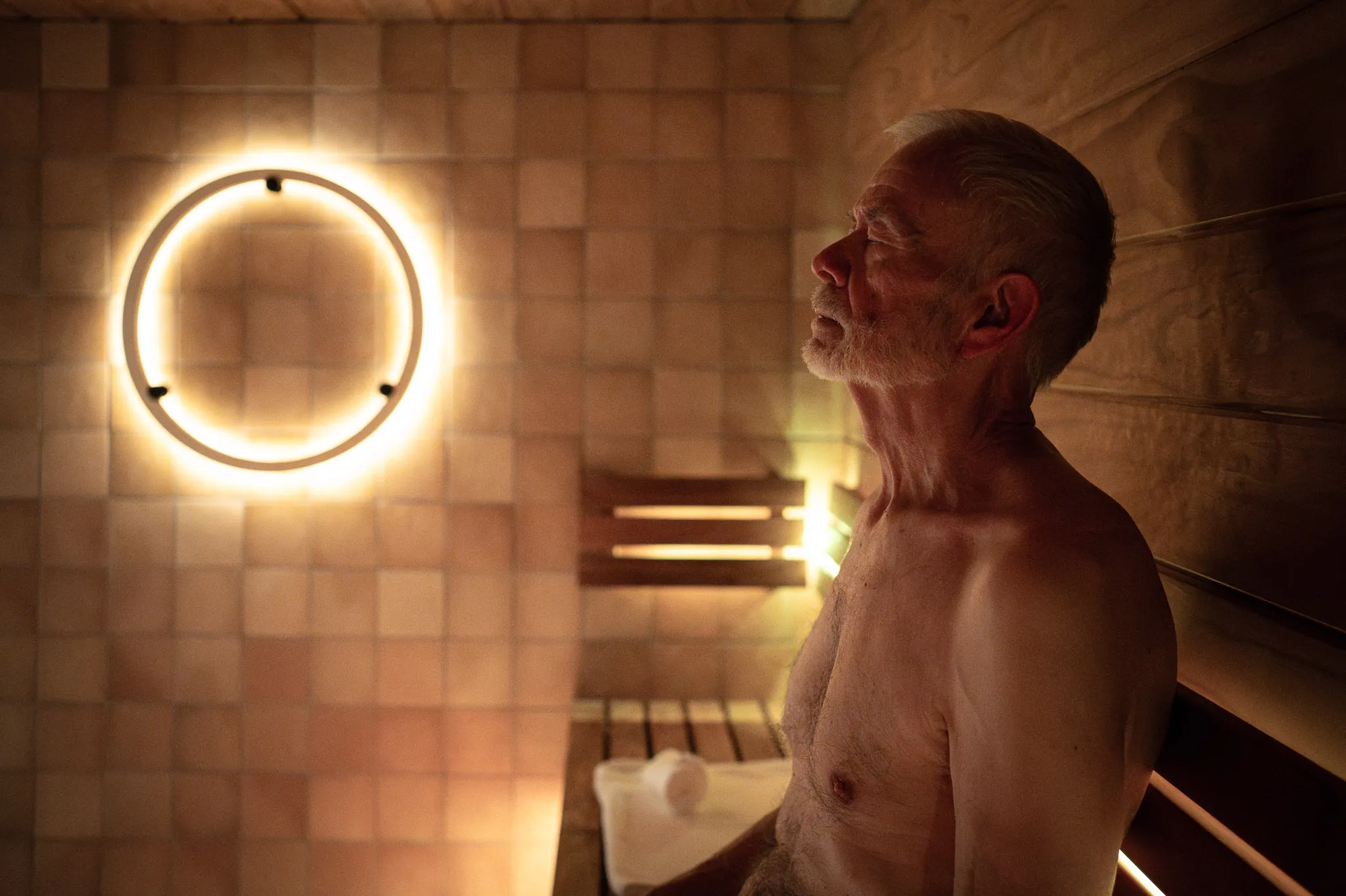 room covered in stone titles with a shower and sauna