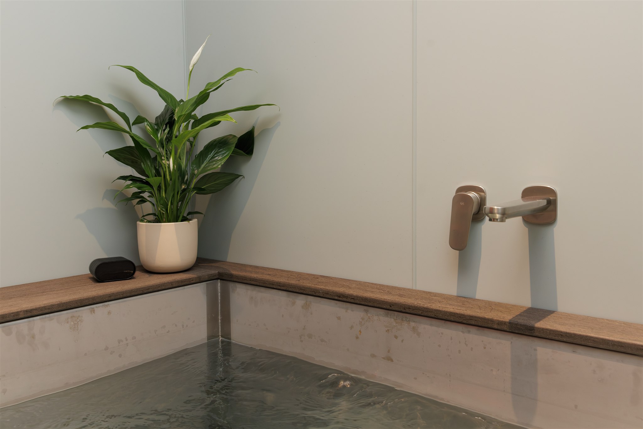 man sitting in ice bath in Remuera O-Studio with her hand on your heart
