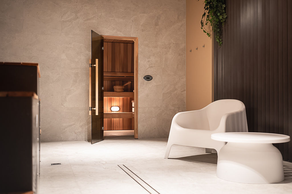 room covered in stone titles with a shower and sauna