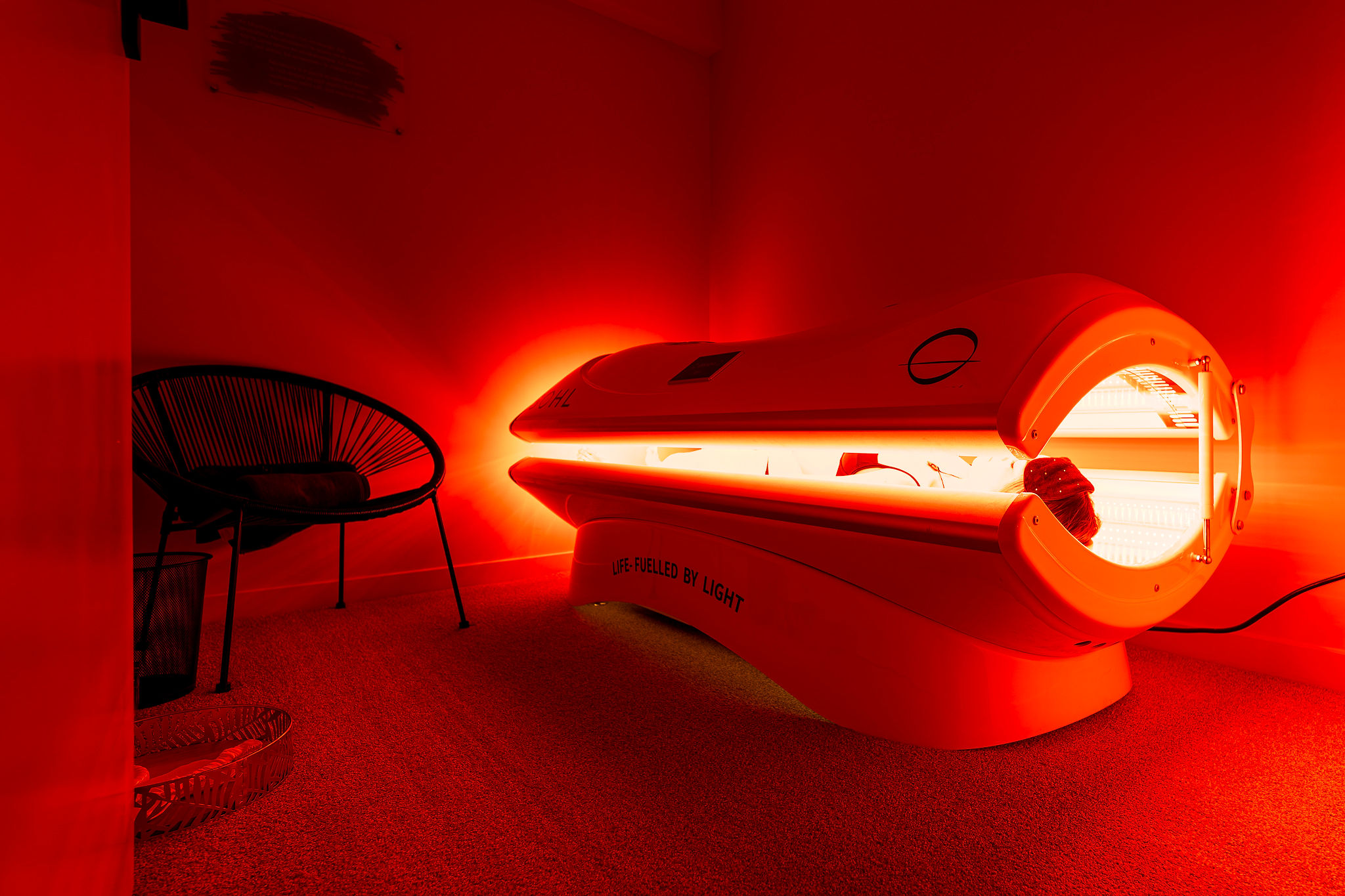 man sitting in ice bath in Remuera O-Studio with her hand on your heart