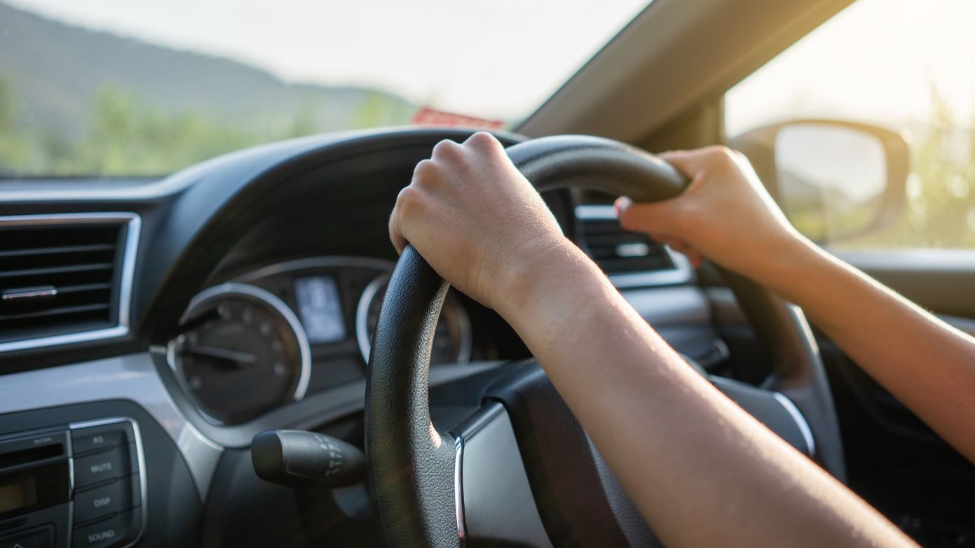 Driving with hand on the steering wheel