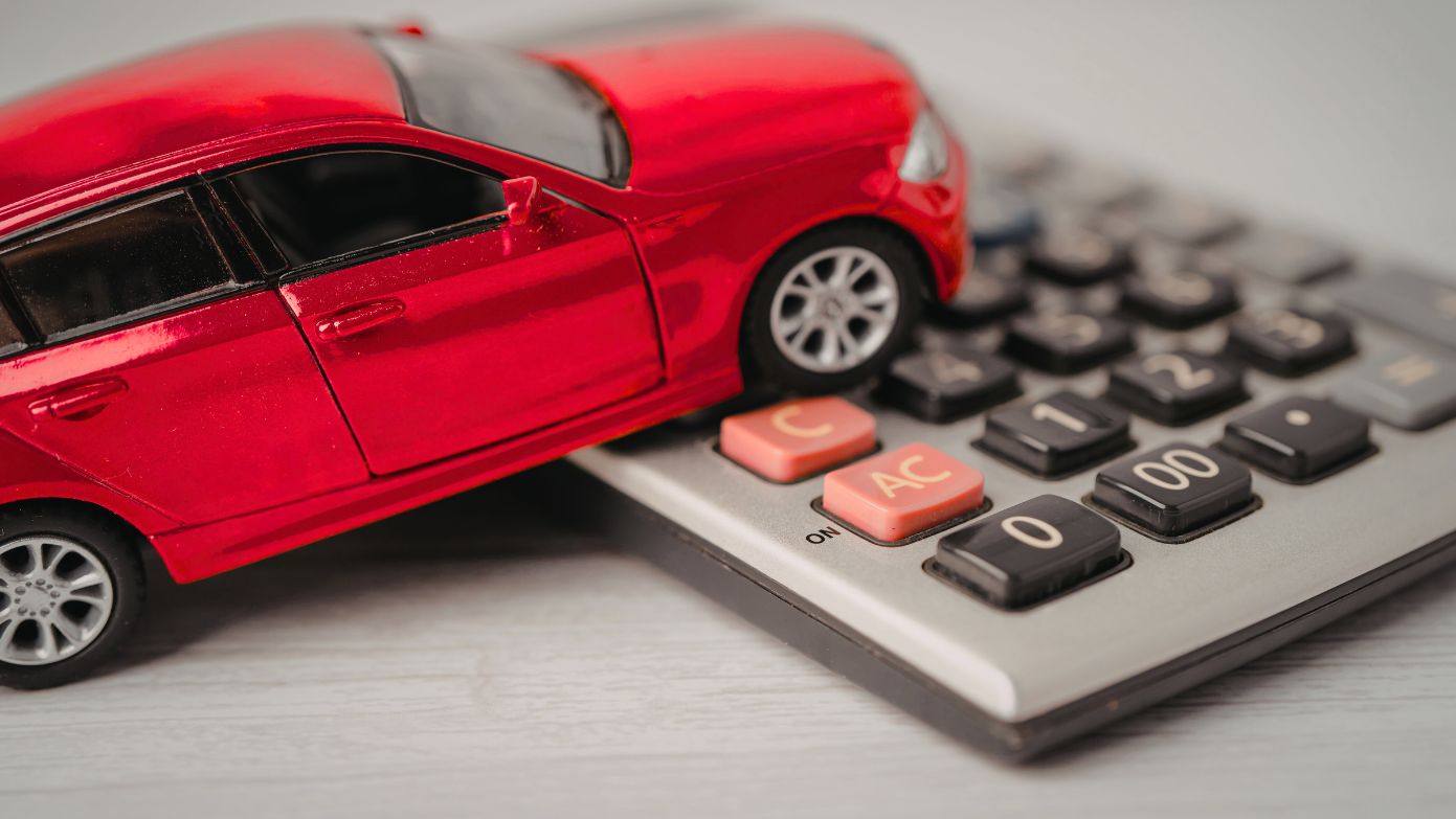 Toy car driving over calculator