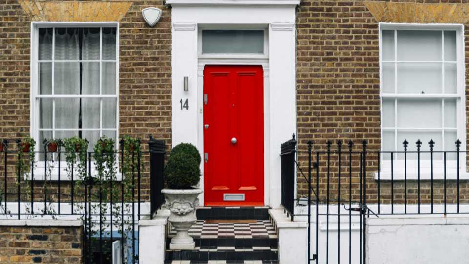Brick house with big windows and a red door