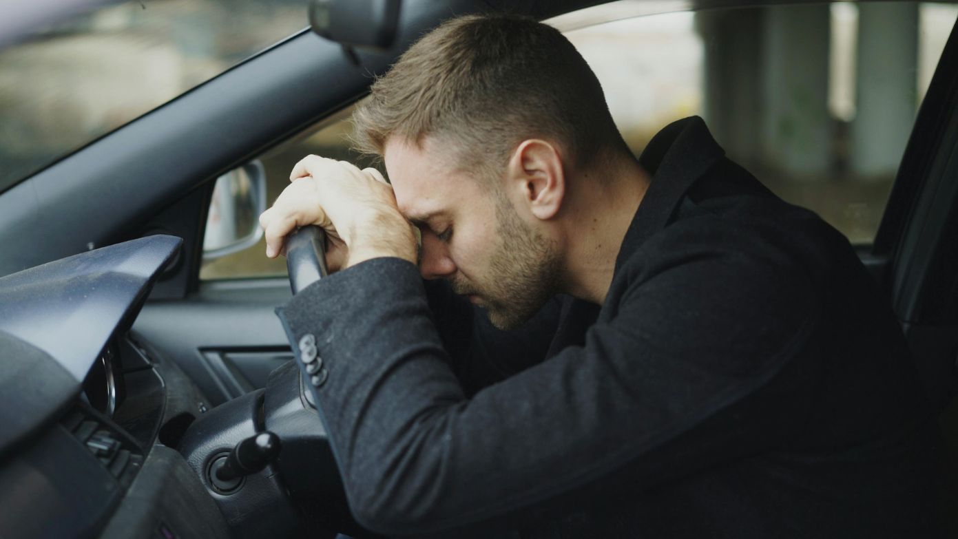 Stressed driver with head on wheel