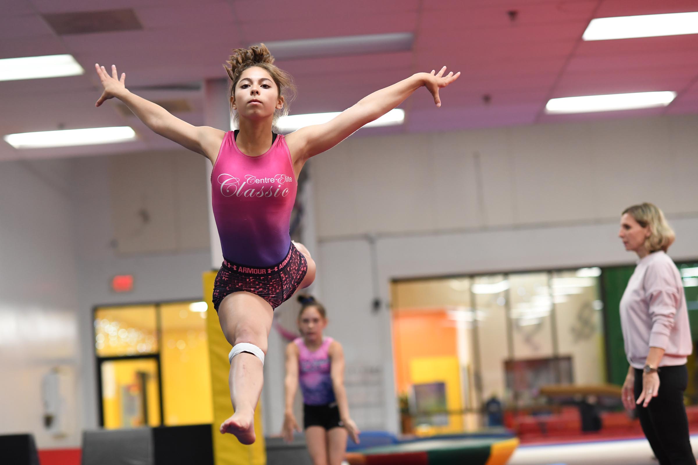 Gymnast performs routine with coach at Aerials Gymnastics Center in Phoenixville Pa