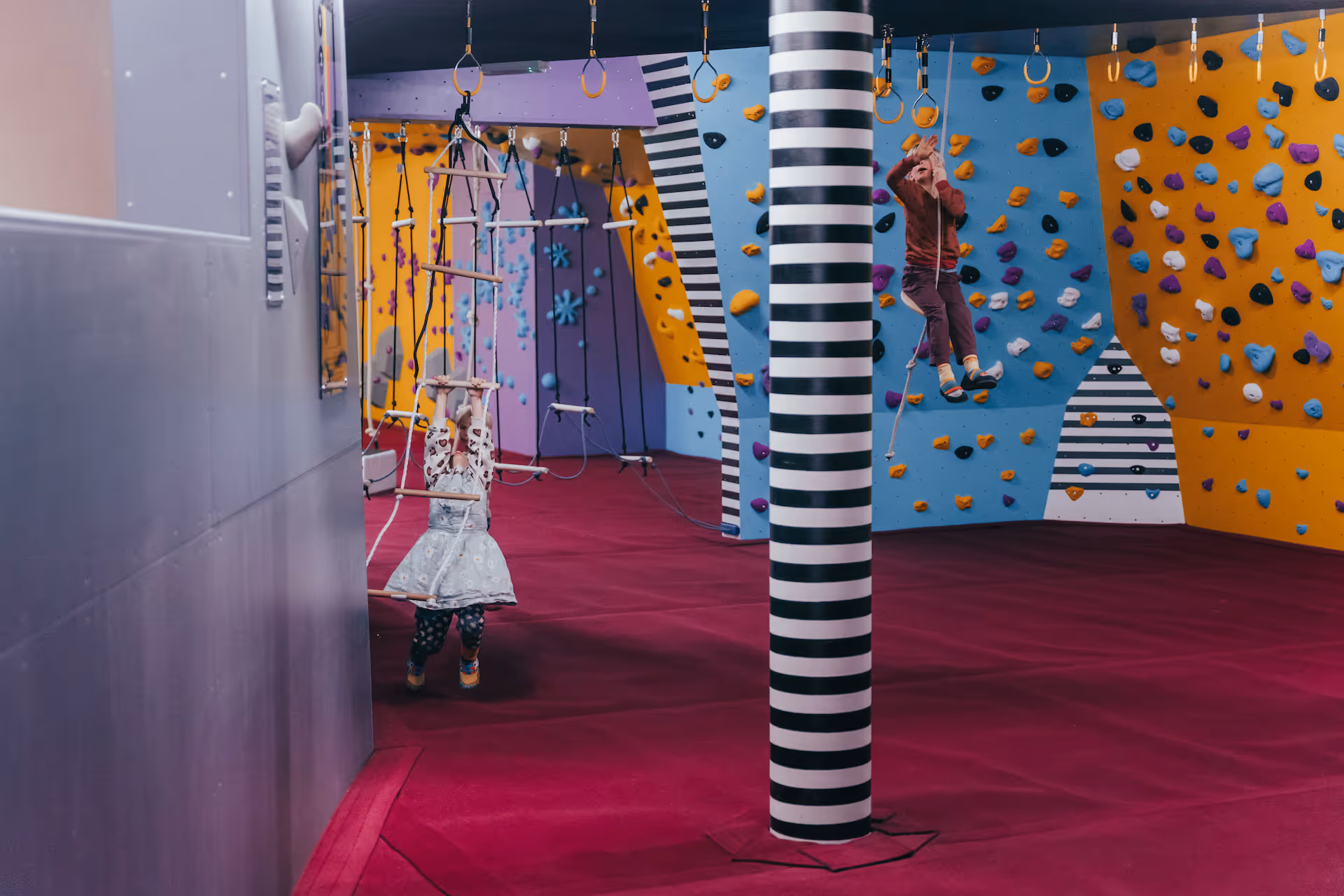 Kinder am Hangeln und Klettern im boulderdrome.