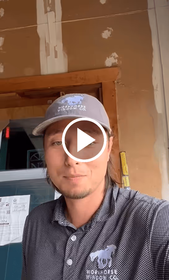Man wearing a gray TopHorse Window Co. cap and polo shirt inside a building under construction.