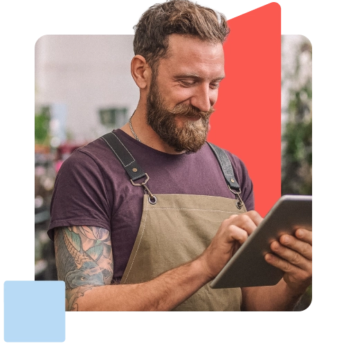 man with apron working on a tablet