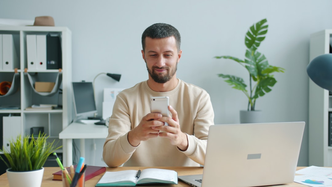Employee recording an authentic video message on a smartphone in an office