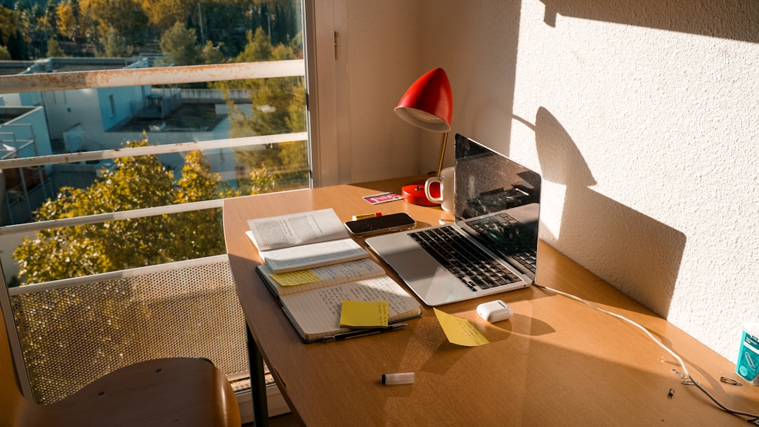 Internal communications manager desk with laptop by a window in natural light