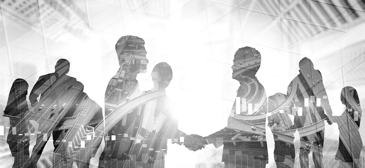 Black and white double exposure image of silhouettes of businesspeople shaking hands, overlaid with modern city highway interchanges and financial data charts.