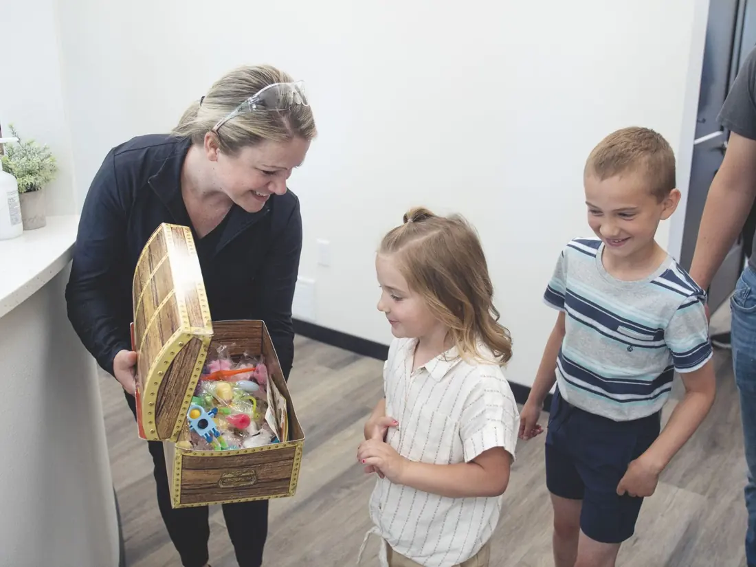 Team member offering kids the treasure chest after their visit