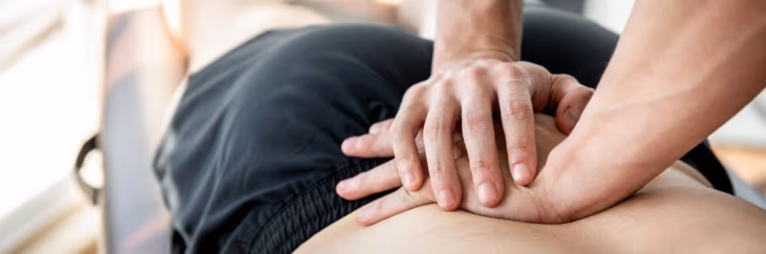 chiropractor making adjustment on patient's back