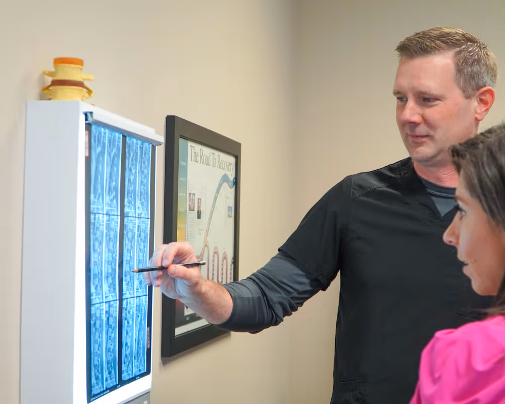 chiropractor showing client x-ray