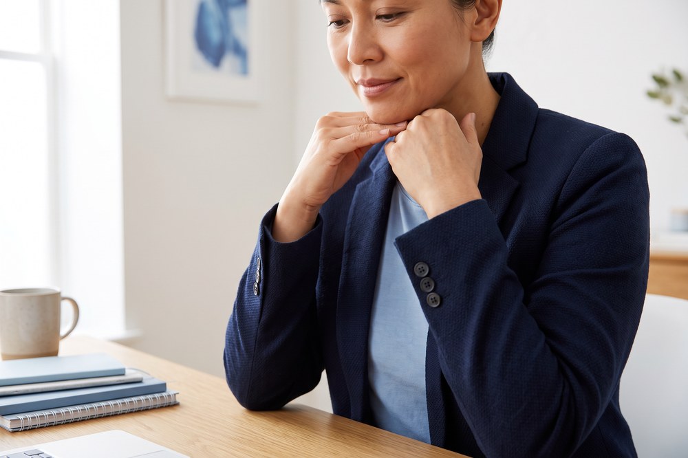 Adult performing a gentle chin tuck stretch for neck tension at a desk