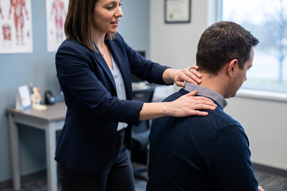 Chiropractor evaluating a patient’s neck and shoulder after a car accident