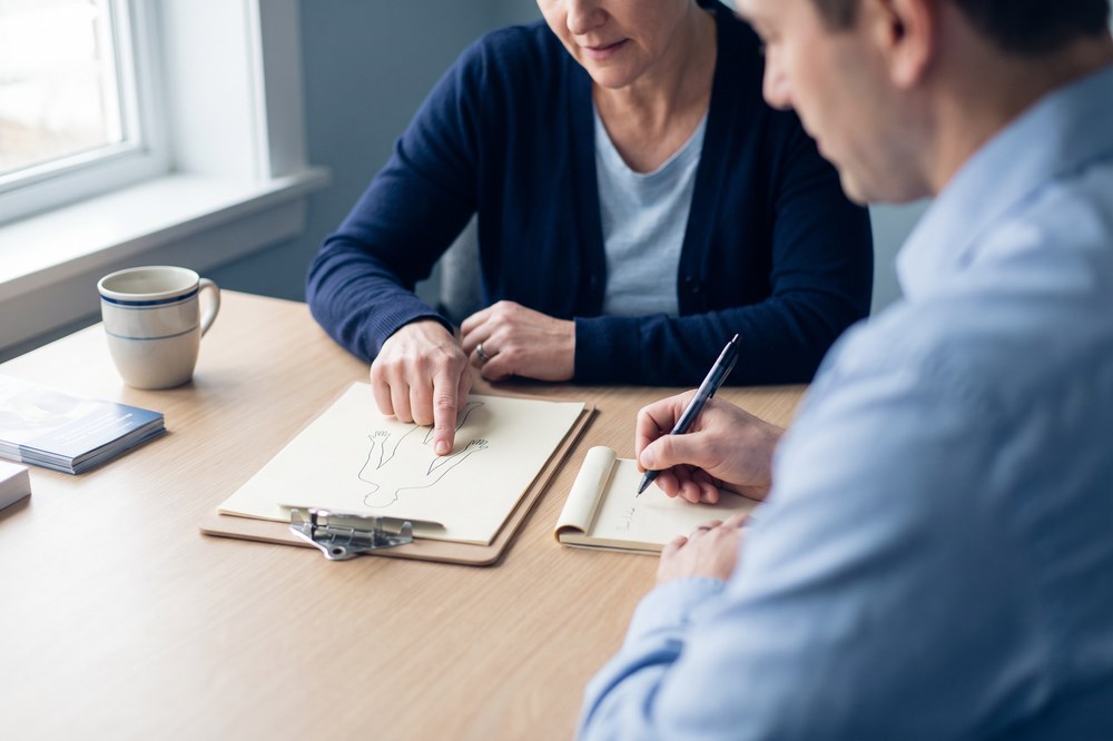 Patient and chiropractor reviewing a body-map intake form after a car accident
