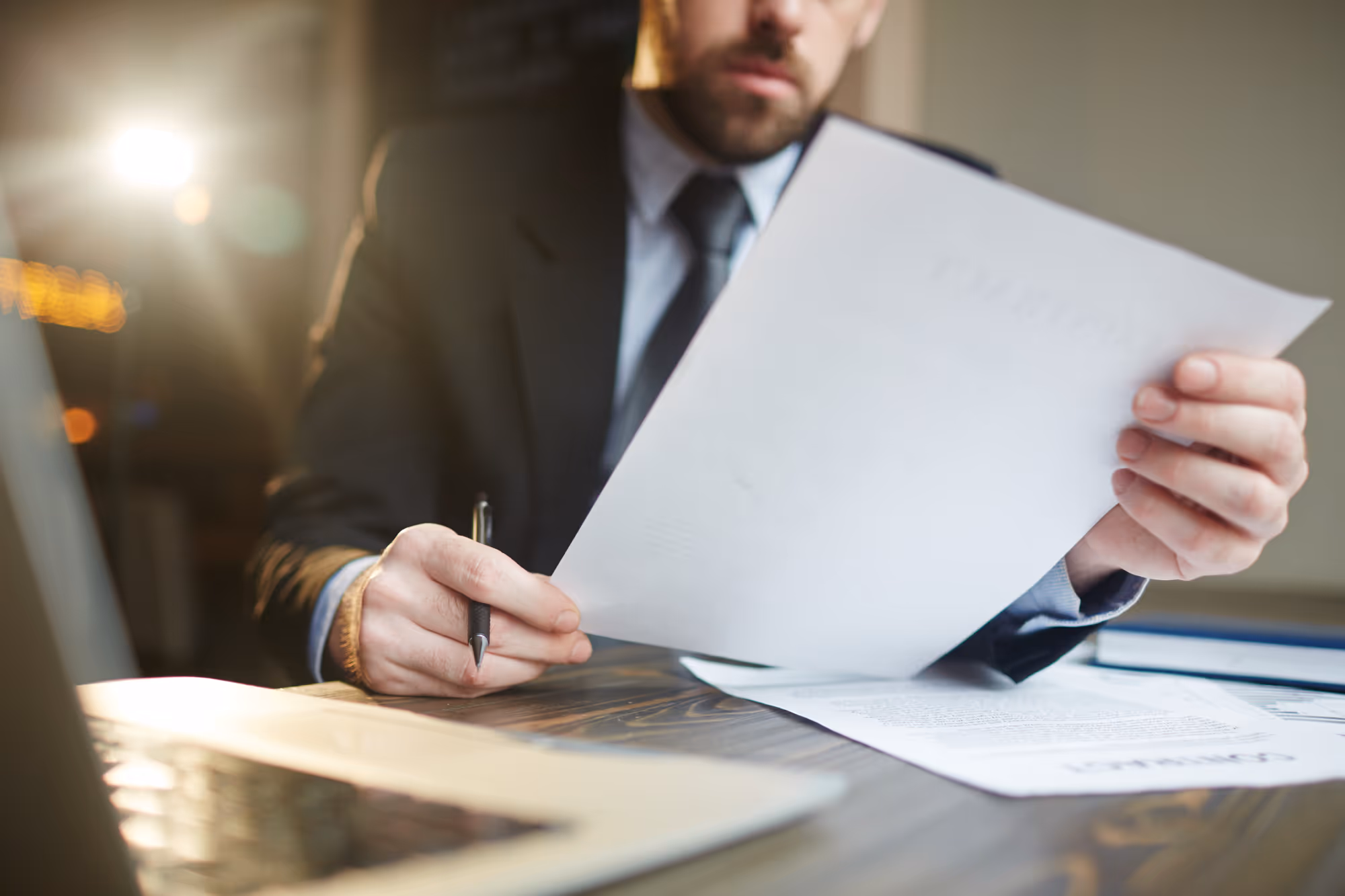 a man in a suit is holding a piece of paper