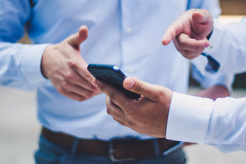 two men are holding their cell phones in their hands