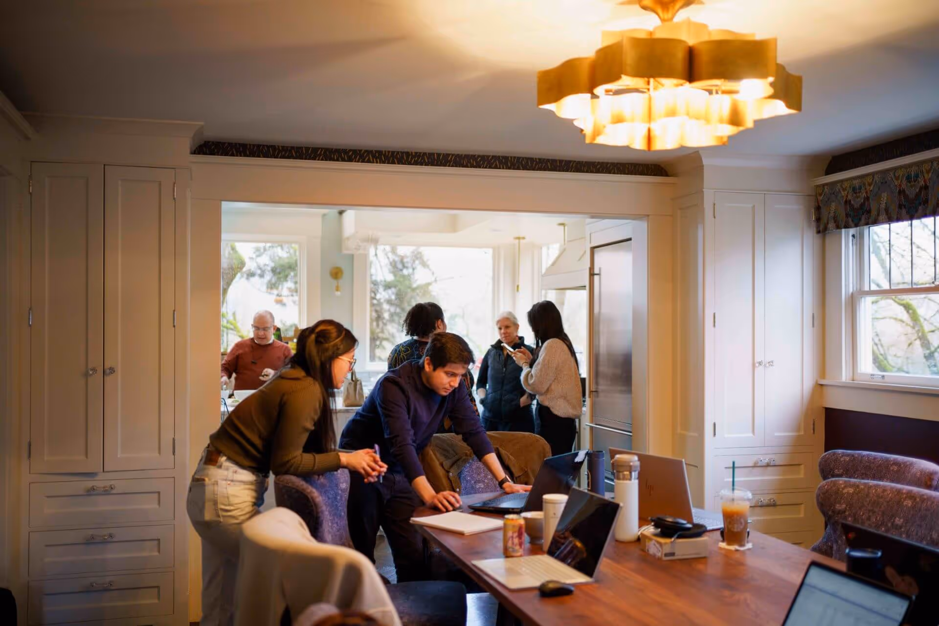 A group of people standing around a wooden table