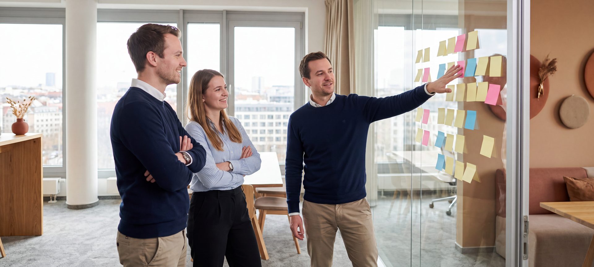 Team einer Immobilienverwaltung bespricht einen Prozessablauf an einer Glaswand