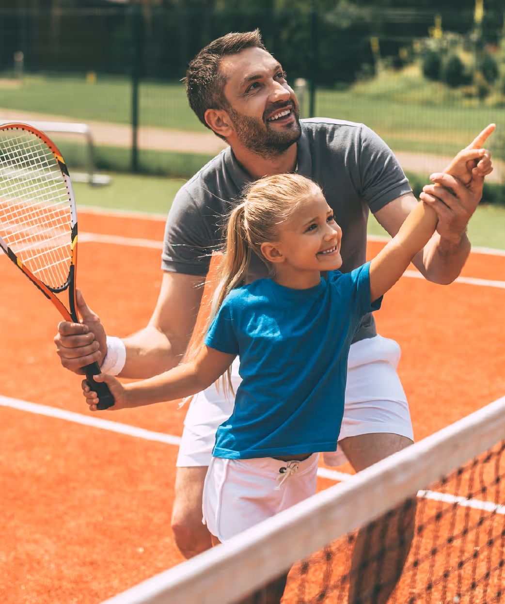 Father teaching daughter tennis