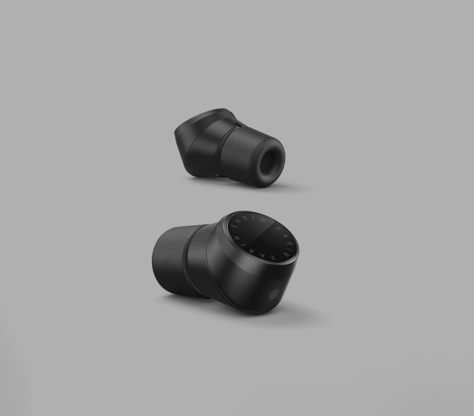 A pair of black modern ear buds on grey background