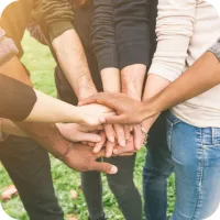 Several hands on top of each other in a huddle.