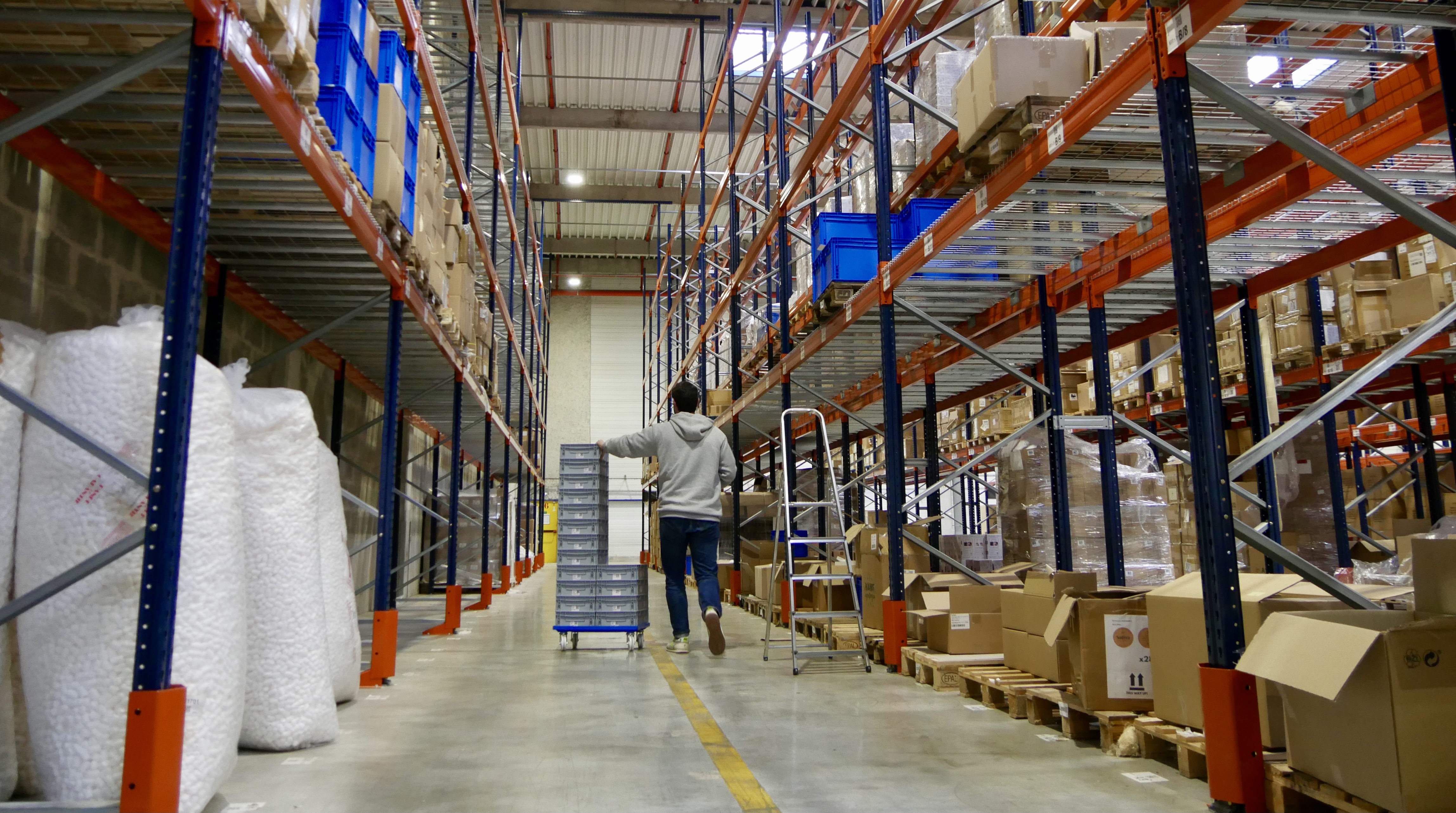 A Hive picker walking through the warehouse to fulfill some orders