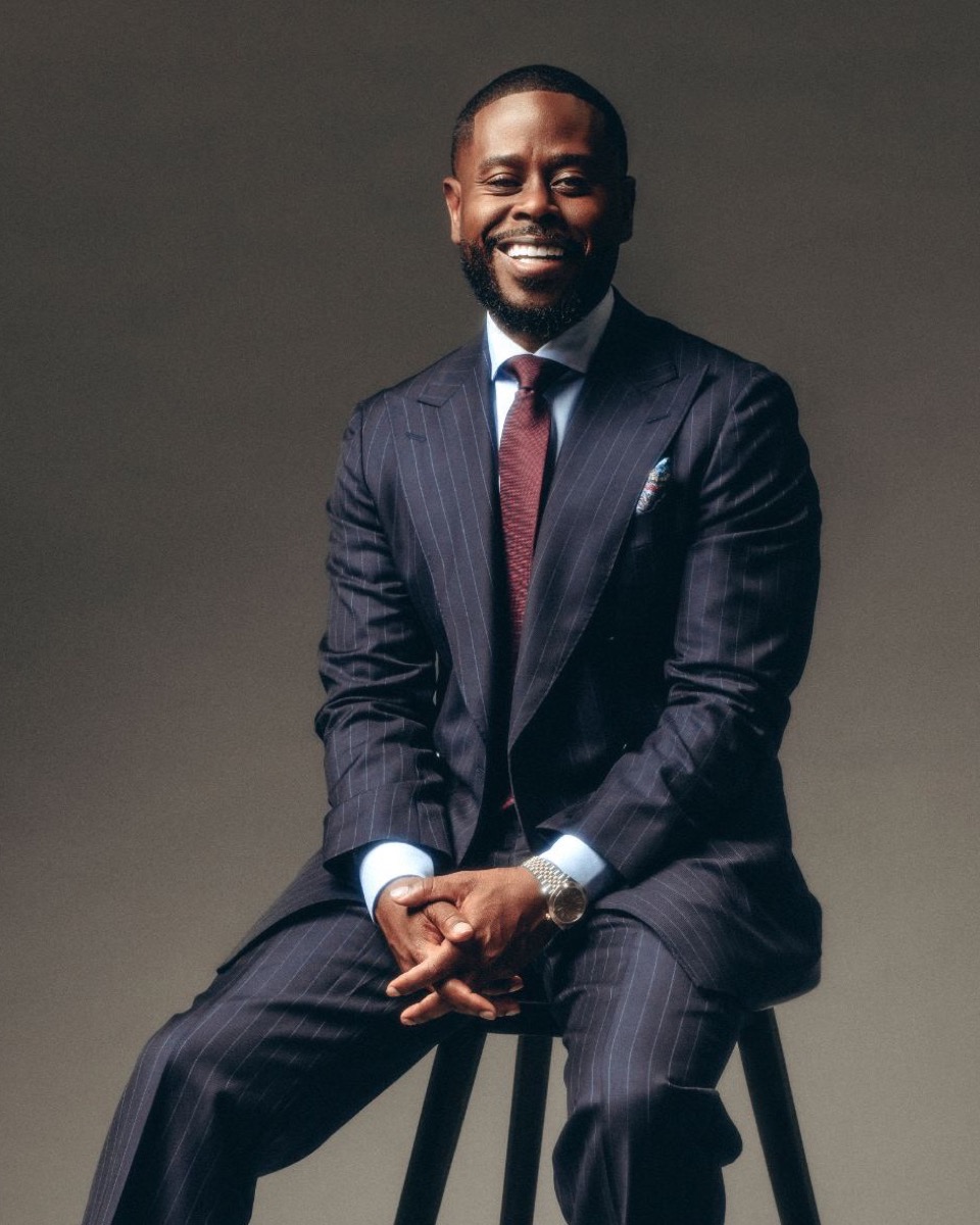 Anthony O'Neal smiling in a black and pink track jacket