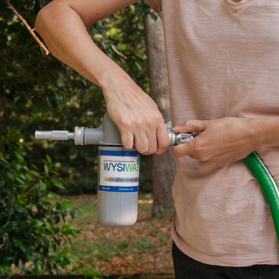 A man attaching WYSIWASH to a hose