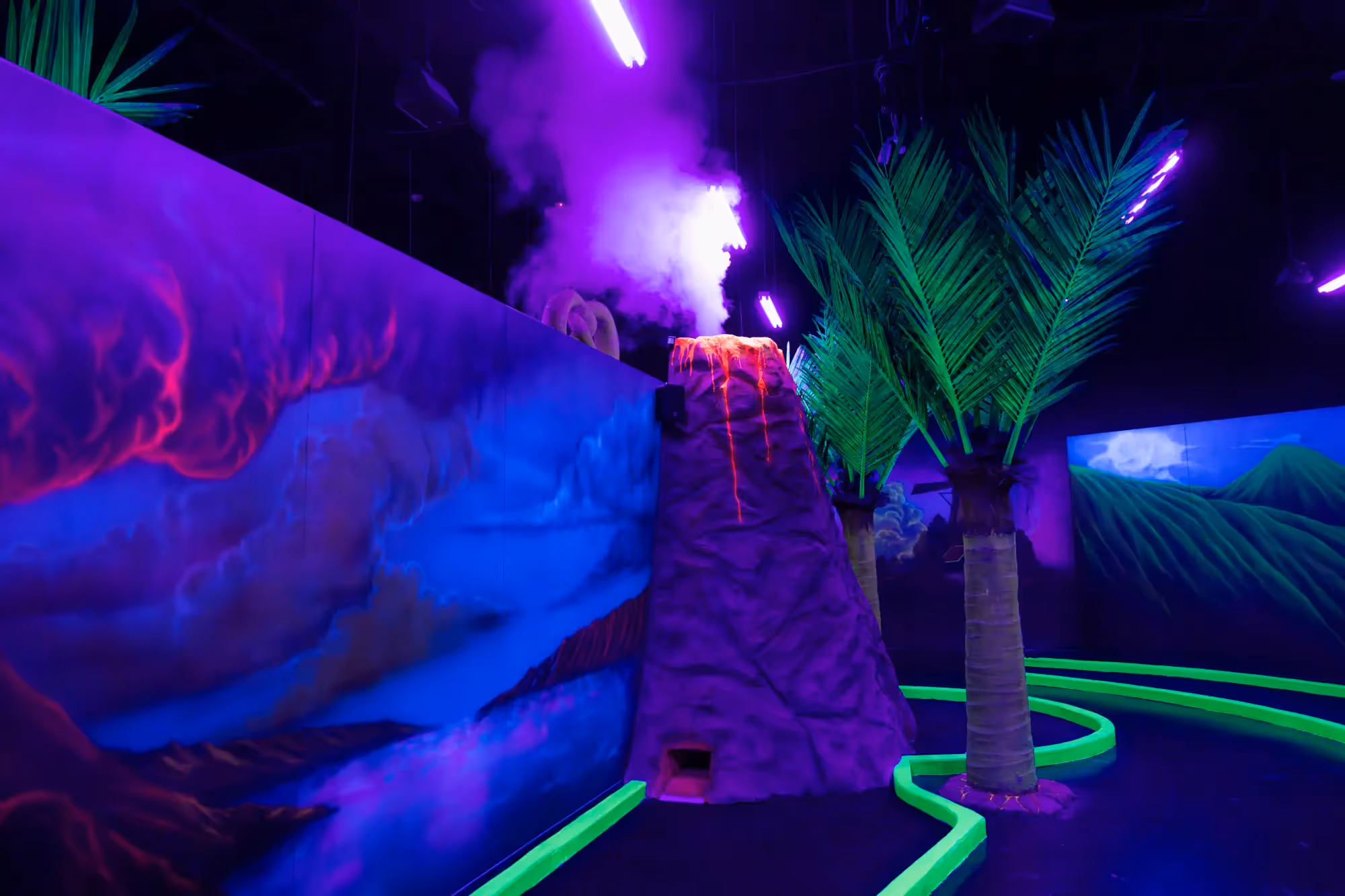 A purple and green neon lit tunnel with a volcano in the center.