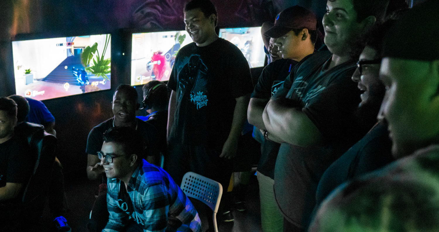 A group of people playing video games in a dark room.