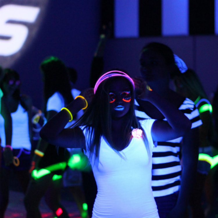 A group of people wearing glowing clothing and face paint.