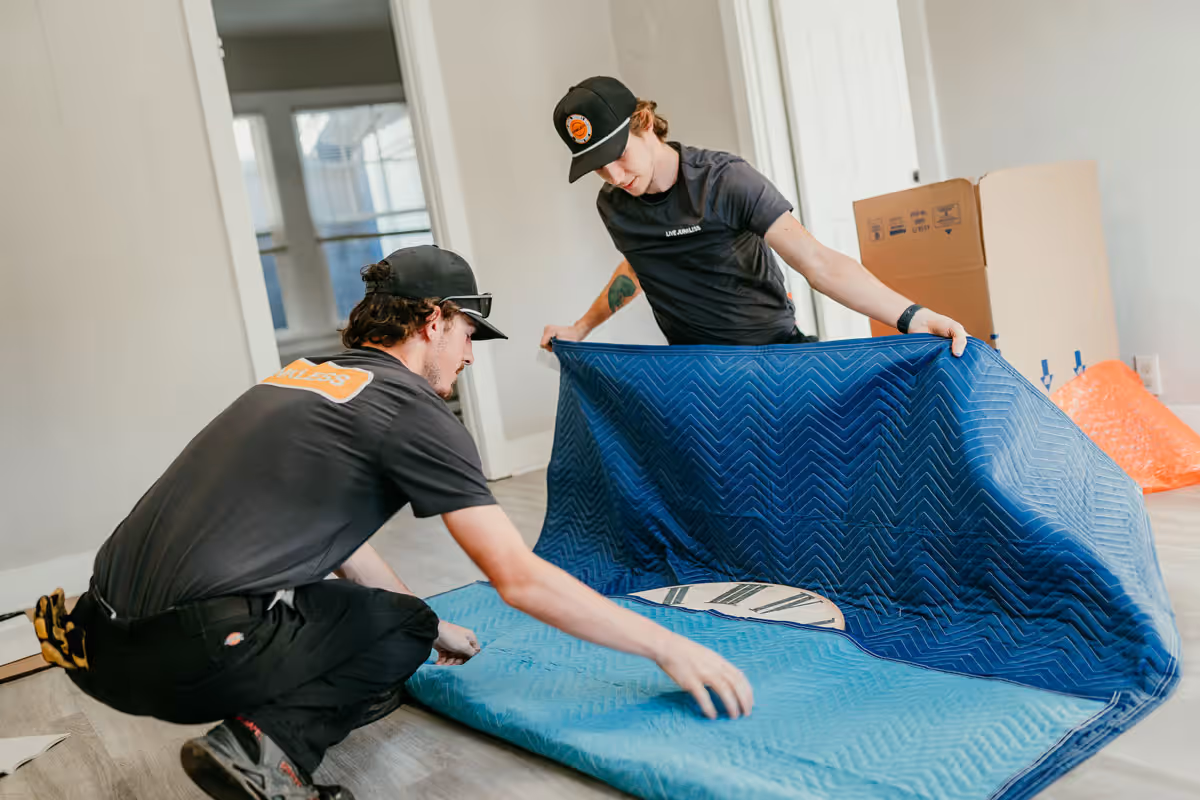 Two Live Junkless movers are packing items carefully.