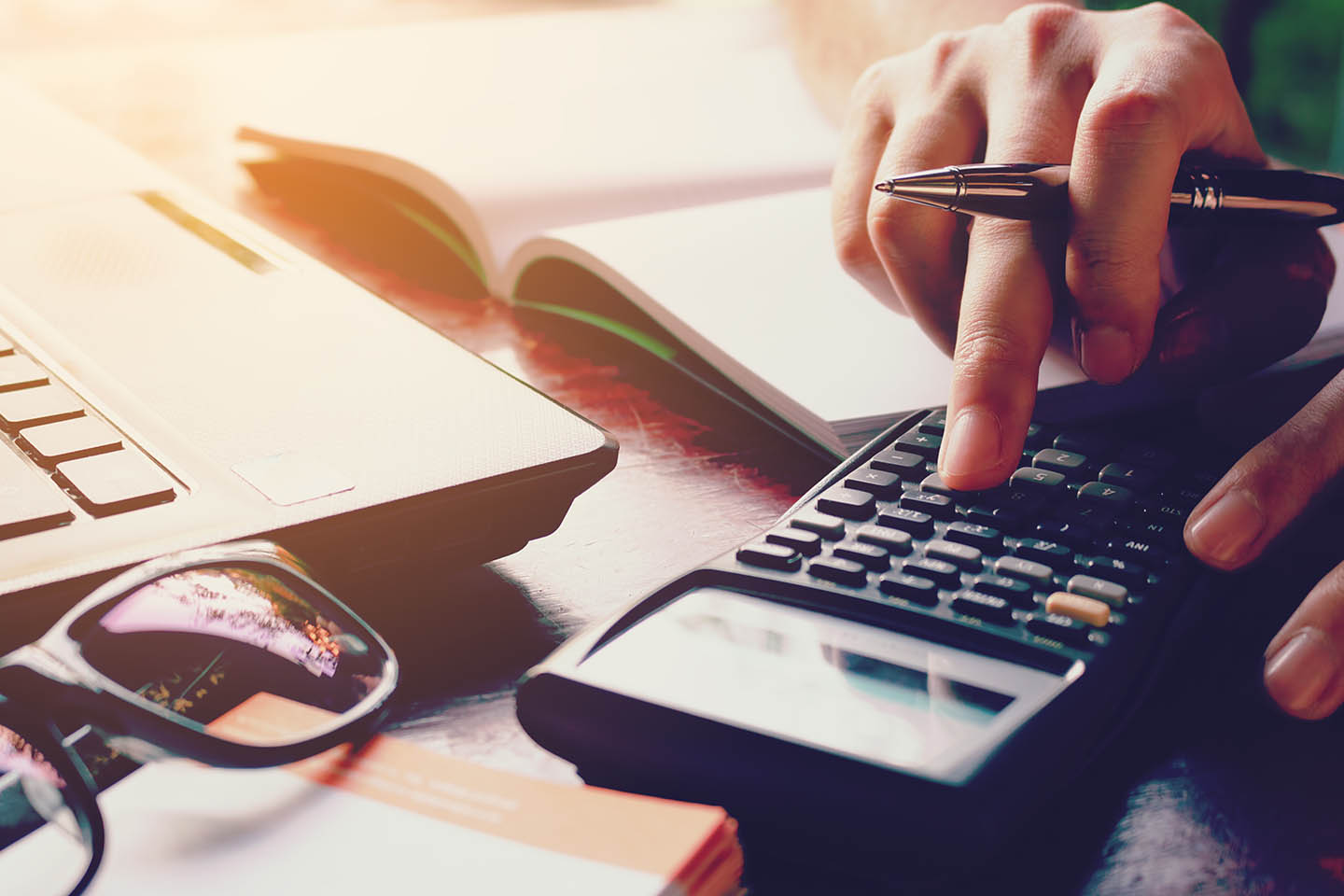 Person using a calculator to budget for the cost of dental implants