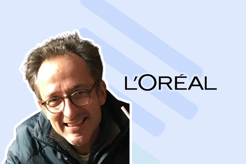 Portrait d'un responsable de L'Oréal à côté du logo de l'entreprise