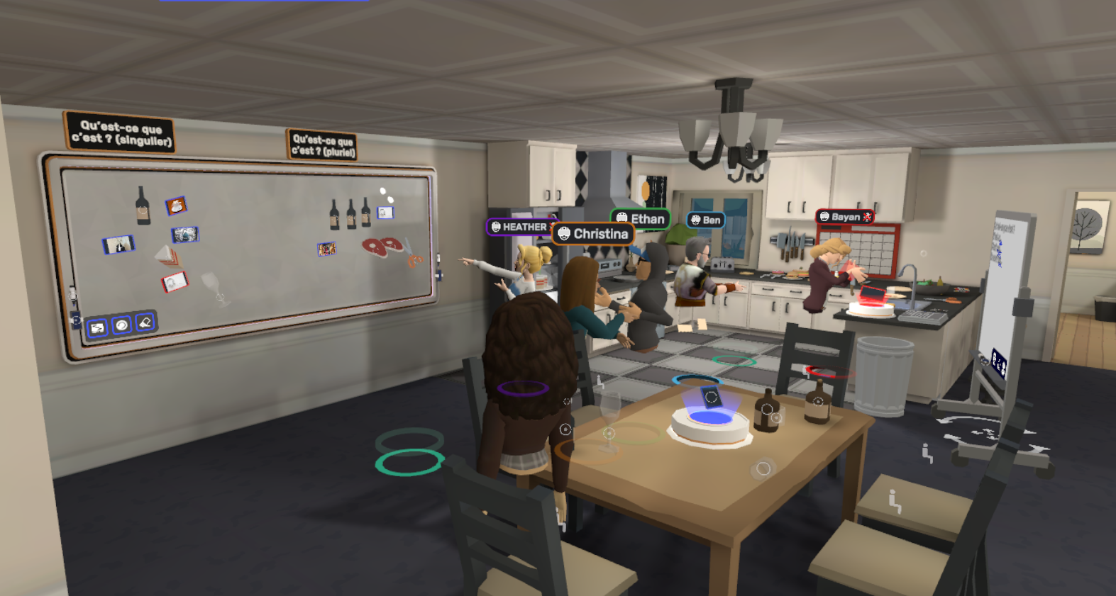 Un grupo de estudiantes en forma de avatares se mueve por un escenario de cocina virtual, donde un pizarrón muestra varios elementos bajo los encabezados “Qu’est-ce que c’est? (singulier)” y “Qu’est-ce que c’est? (pluriel).”